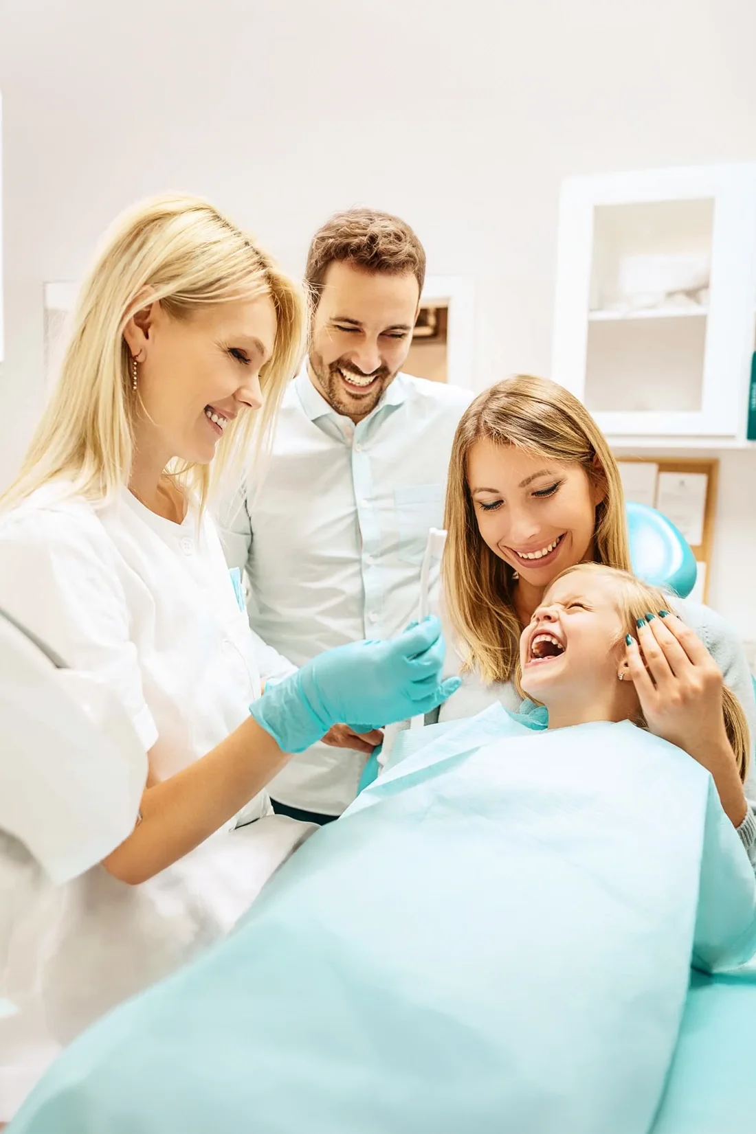 Dentist smiling with family patients inside the Refined Smiles office